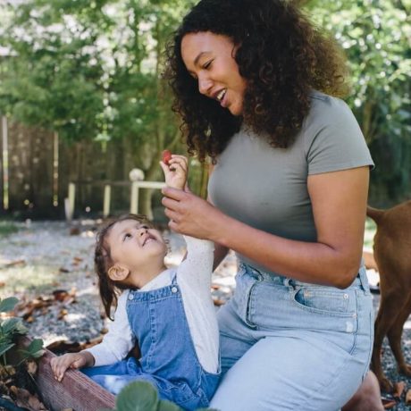 woman playing with child in garden