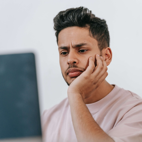 Puzzled looking man staring at a computer screen