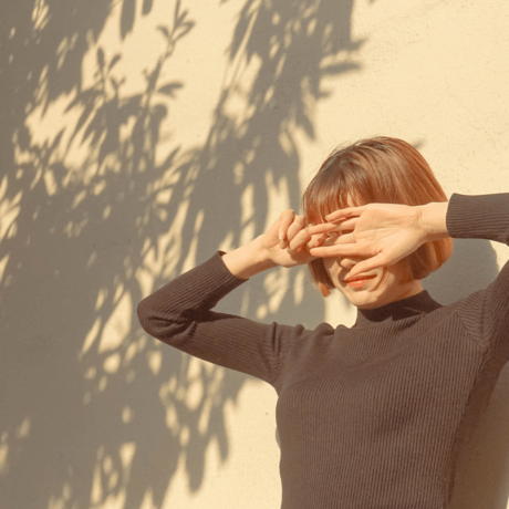 Woman blocking the sun out of her eyes with her hands