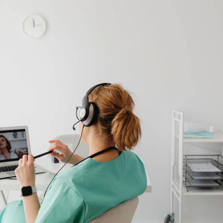 Woman sitting at a desk video chatting a doctor