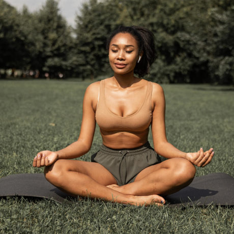 Woman doing yoga in an open field