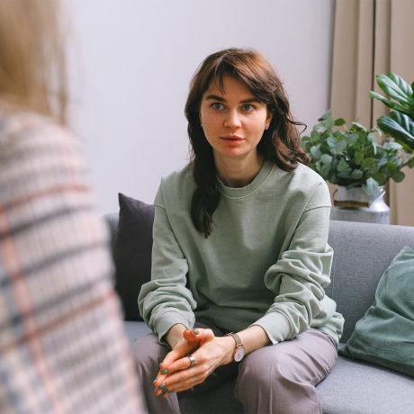 Woman sitting on a couch receiving help for suicidal thoughts