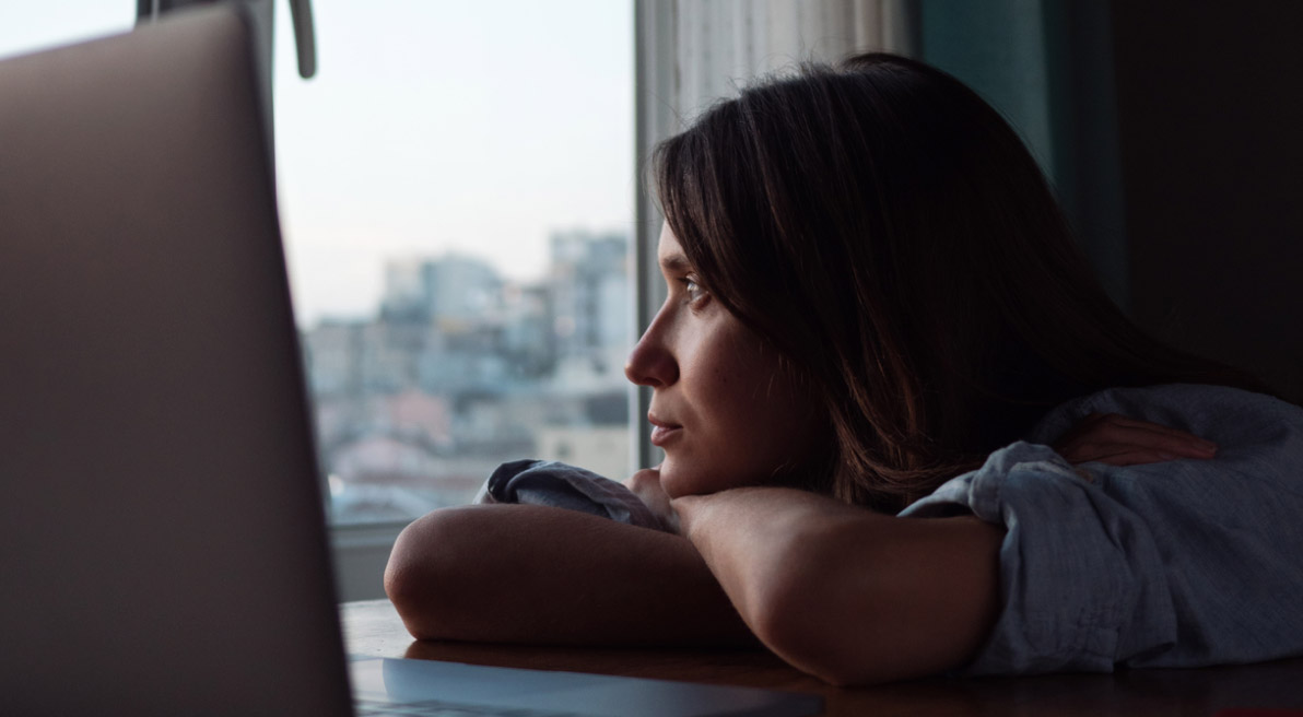 woman looking out a window and contemplating