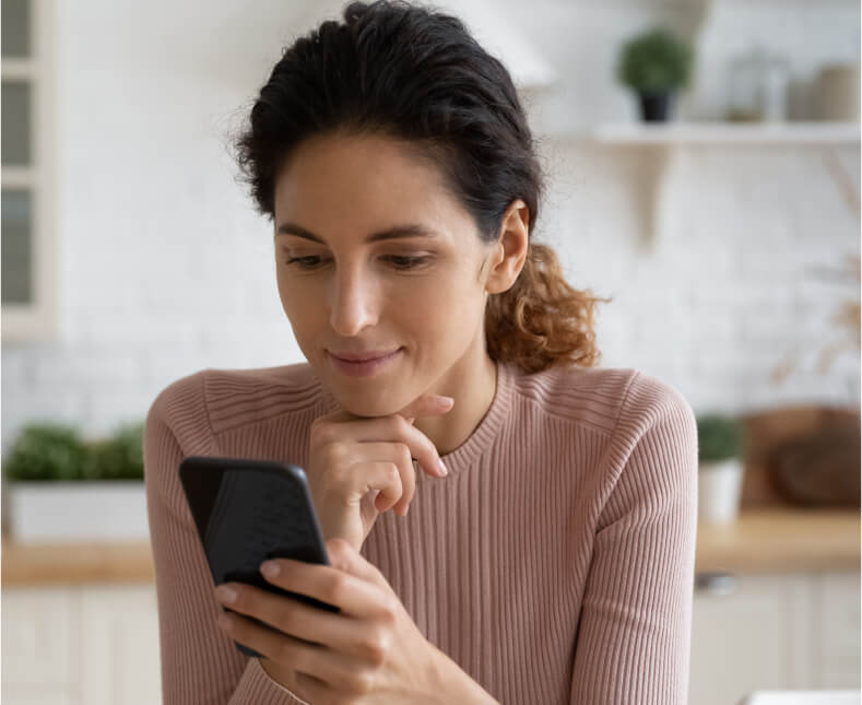 woman looking at phone and smiling